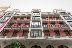 a tall red building with windows and balconies at Petit Palace Chueca in Madrid