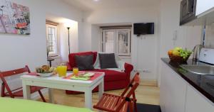 ein Wohnzimmer mit einem roten Sofa und einem Tisch in der Unterkunft Alfama 44 in Lissabon