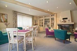 a living room with a table and chairs and a fireplace at Hotel Jaume in Alp