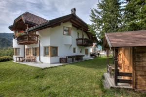 a house with two balconies and a yard at Alexander Mountain-Lodge in San Vigilio Di Marebbe