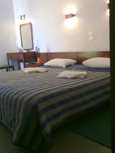 a bedroom with a bed with two towels on it at Violetta in Kamena Vourla