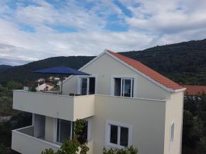 a white house with an umbrella on top of it at Captain's Attic in Račišće