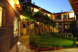 une maison avec une cour ornée de plantes et une table dans l'établissement La Tosca Hostel, à Puerto Madryn