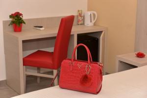 a red purse sitting next to a desk with a red chair at Eden Rooms in La Spezia