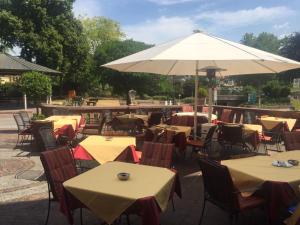 ein Restaurant im Freien mit Tischen und einem Sonnenschirm in der Unterkunft Hotel Restaurant Schwan in Wertheim