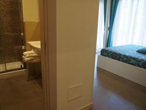 a bathroom with a bed and a sink next to a window at Endro's Rooms in Monterosso al Mare