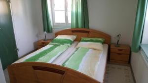 2 Einzelbetten in einem Zimmer mit grünen Vorhängen in der Unterkunft Ferienwohnung Alwind 5 in Lindau
