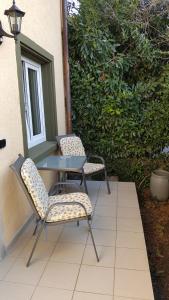 2 Stühle und ein Tisch auf der Terrasse in der Unterkunft Ferienwohnung Alwind 5 in Lindau