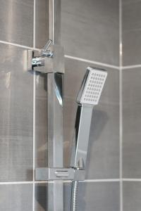 a shower with a faucet in a bathroom at Bluestone Apartments - Didsbury in Manchester