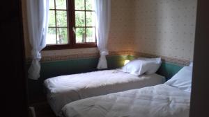 duas camas num quarto com duas janelas em Gite du Vieux Charme em Saint-Amand-en-Puisaye