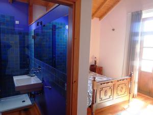 a bathroom with a sink and a blue tiled wall at Solar do Alambique in Angeja