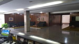 a lobby with a waiting room with couches and a television at Fenícia Palace Hotel in Bauru