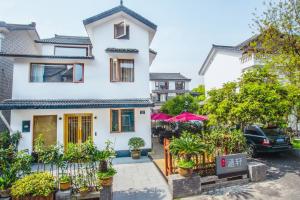 a white house with plants in front of it at Han Xuan Boutique Hostel in Hangzhou