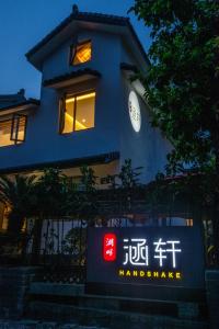 een blauw gebouw met een bord ervoor bij Han Xuan Boutique Hostel in Hangzhou