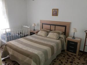 アビラにあるAlojamiento Familiar Conde Don Ramonのベッドルーム1室(ベッド1台、ナイトスタンド2台、ランプ2つ付)