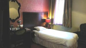 Habitación de hotel con cama y espejo en The Briar Rose Wetherspoon en Birmingham