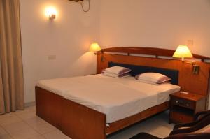 1 dormitorio con 1 cama de madera y 2 almohadas en YKD Tourist Rest Hikkaduwa, en Hikkaduwa