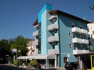 un edificio azul con balcones en una calle de la ciudad en Albergo Aquila, en Lido di Jesolo