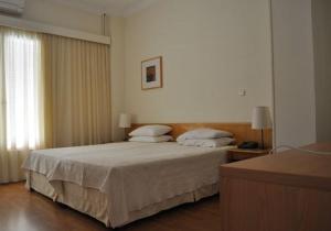 ein Schlafzimmer mit einem großen Bett mit zwei Kissen in der Unterkunft Miami Hotel in Mati