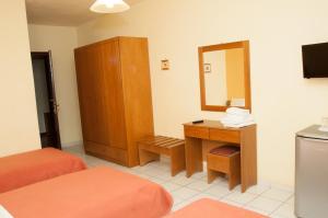 a hotel room with a vanity and a mirror at Pineas in Kalabaka