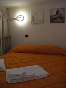レッチェにあるSuite Li Figuliのベッドルーム1室(オレンジ色のベッドカバー付)