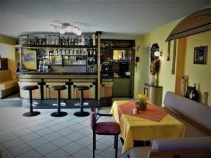ein Restaurant mit einer Bar mit Tisch und Stühlen in der Unterkunft Pension Pfefferdohle in Velden am Wörthersee