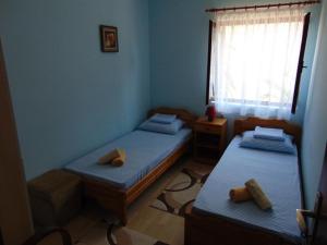 two twin beds in a room with a window at Apartman Sucuraj in Sućuraj