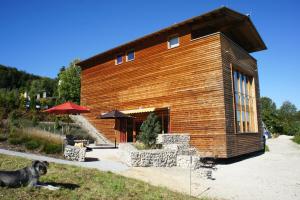 a wooden building with a dog sitting in front of it at Alb Lodge in Gomadingen