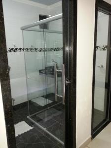 uma cabina de duche em vidro na casa de banho com um lavatório em Shopping Motel Santa Maria do Pará em São Jorge