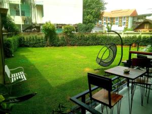 a view of a yard with a table and chairs at Hotel De Nara-SHA Extra Plus in Chiang Mai