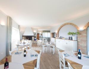 jadalnia z białymi stołami i białymi krzesłami w obiekcie Agriturismo Fattoria di Monticello w mieście San Venanzo