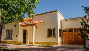 a large white house with wooden doors at Casa Las Parras in San Rafael