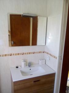 ein Bad mit einem Waschbecken und einem Spiegel in der Unterkunft Estoril House Family in Estoril