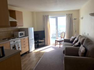 un soggiorno con divano e cucina di Beau Rivage a St Brelade