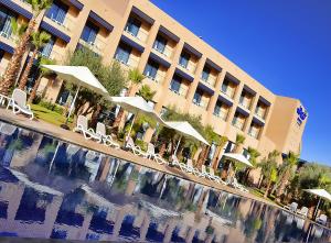 a hotel with chairs and a pool in front of it at Wazo Hotel in Marrakech