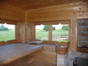 Cabaña de madera con ventanas y banco. en Walter Ranch, en Kaskantyú