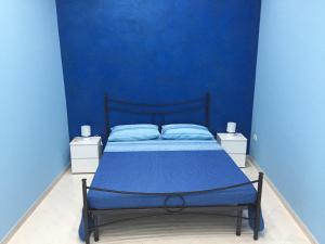 a blue bedroom with a bed with a blue wall at La Casa di Simone in Avola