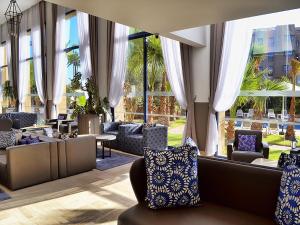 a lobby with couches and chairs and windows at Wazo Hotel in Marrakech