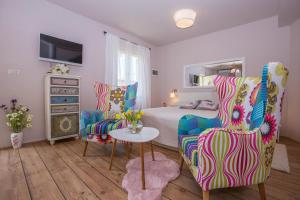 1 dormitorio con 1 cama, 2 sillas y mesa en Apartments Javor, en Rovinj
