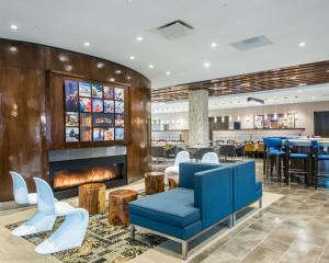 a hotel lobby with a fireplace and a restaurant at Cambria Hotel McAllen Convention Center in McAllen