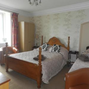 a bedroom with a bed and a chair at Albert Hotel in Peterhead