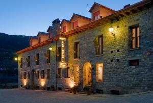 ein großes Steingebäude mit Licht in der Unterkunft Hotel Castillo d'Acher in Siresa