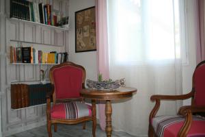Zimmer mit einem Tisch, 2 Stühlen und einem Fenster in der Unterkunft Chambres d'hôtes Le Puid de Gauthier in Saturargues