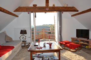 sala de estar con sofá, mesa y TV en Gîte de montagne -Bellefosse Alsace, en Bellefosse