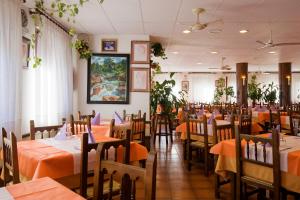 a dining room with orange tables and chairs at Hotel Castillo d'Acher in Siresa