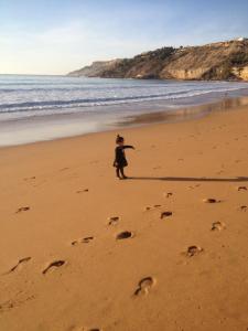 un enfant se promenant sur la plage avec des empreintes dans le sable dans l'établissement Etablissement moderne, à Safi