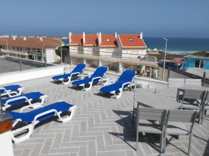 un gruppo di sedie e tavoli blu su un tetto di Baleal 4 Surf a Baleal