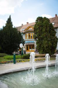 a water fountain in front of a building at Titán Apartman in Gyula