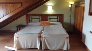 Dormitorio con cama con almohada naranja en Apartamentos Santana en Llanes