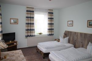 a hotel room with two beds and a window at Pension Goerke in Kritzkow